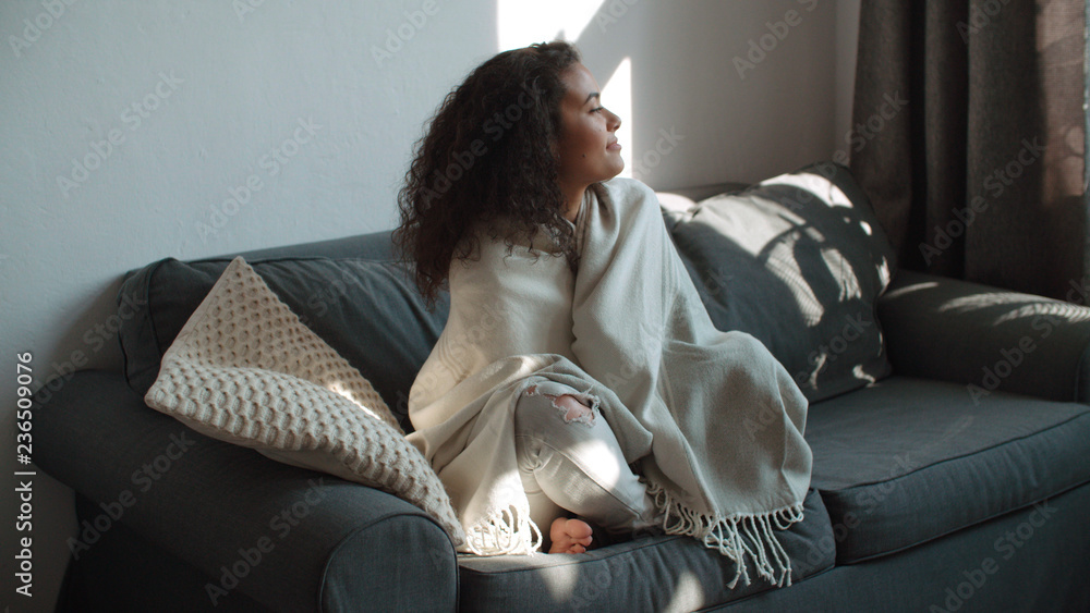 © therabbithole - Happy beautiful woman sitting on sofa wrapped in blanket relaxing at home. © therabbithole - Happy beautiful woman sitting on sofa wrapped in blanket relaxing at home.