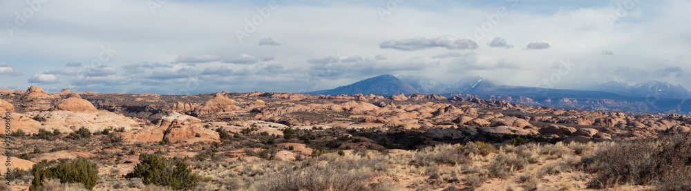 Panoramic Landscape view of beautiful red rock canyon formations during a vibrant sunny day. Taken in Arches National Park, located near Moab, Utah, United States. Panoramic Landscape view of beautiful red rock canyon formations during a vibrant sunny day. Taken in Arches National Park, located near Moab, Utah, United States.