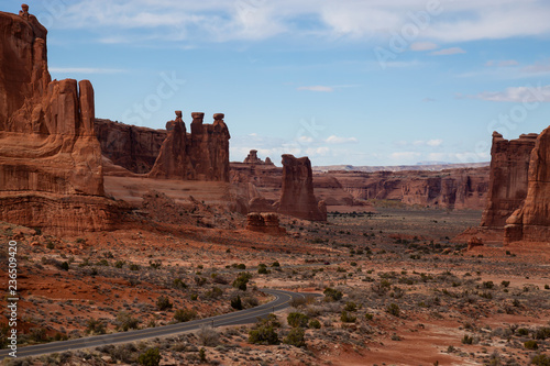 Panoramic landscape view of a Scenic road in the red rock canyons during a vibrant sunny day. Taken in Arches National Park, located near Moab, Utah, United States.