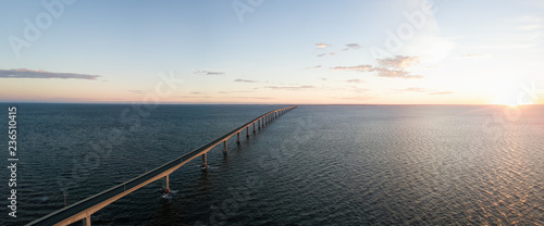 Aerial Panoramic view of Confederation Bridge to Prince Edward Island during a vibrant sunny sunrise. Taken in Cape Jourimain National Wildlife Area, New Brunswick, Canada. photo