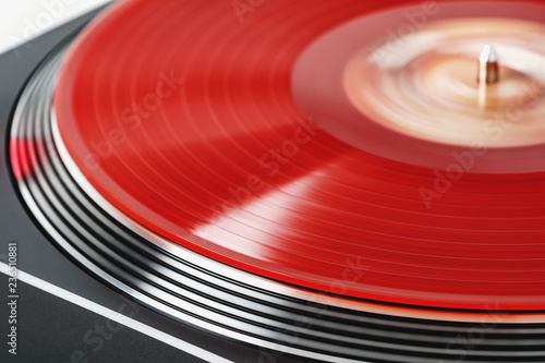 Vinyl record rotate. A ray of light on a piece of vinyl. Turntable player. Sound technology for DJ to mix and play music. Red vinyl. The texture of the bands on the vinyl record. Turntable player