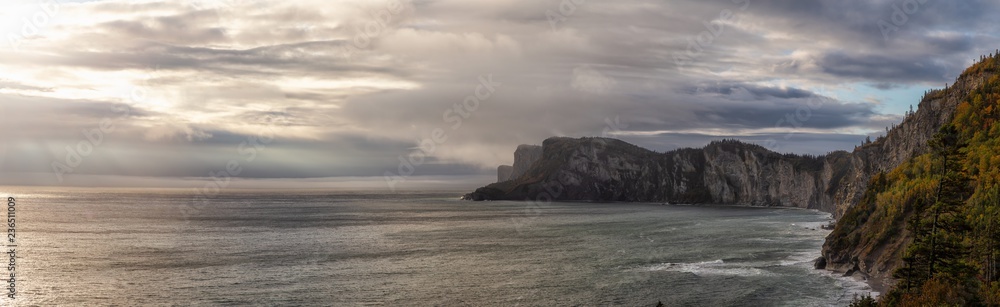 Striking panoramic landscape of a rocky coastline during a cloudy sunrise. Taken in Forillon National Park, near Gaspé, Quebec, Canada.