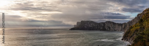 Striking panoramic landscape of a rocky coastline during a cloudy sunrise. Taken in Forillon National Park, near Gaspé, Quebec, Canada.