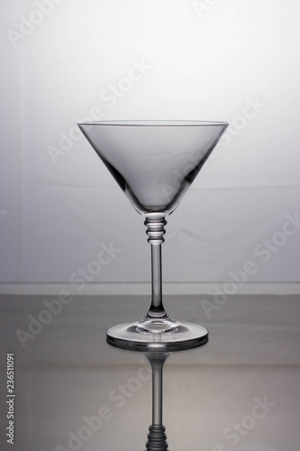 Empty transparent cocktail glass on a light background