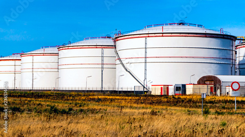 Obraz na płótnie Storage tanks for petroleum products. Equipment refinery . White tanks for petrol and oil in tank farm with blue sky w salonie