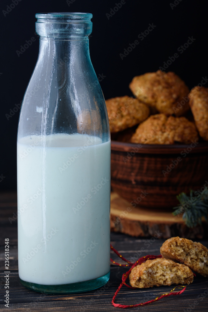 Appetizing and tasty oatmeal cookies with raisins and milk in a dark vein on the table Appetizing and tasty oatmeal cookies with raisins and milk in a dark vein on the table