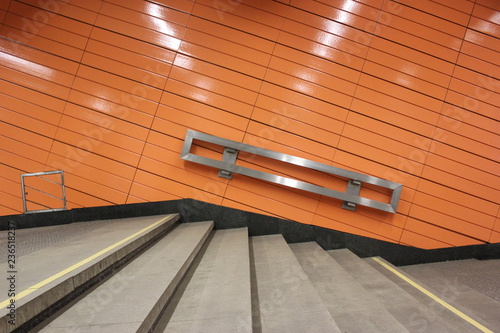 orange wall and stair steps into metro interior