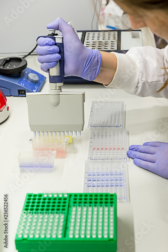 Female scientist using a pipette in a DNA laboratory photo