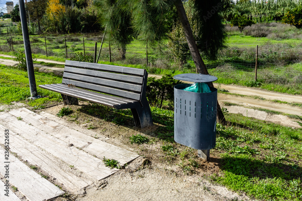 Street bench next to the modern garbage bin. Street bench next to the modern garbage bin.