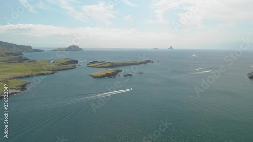 Pleasure boats leave harbor pass small islands and head out into vast open sea towards Blasket Islands in the Atlantic Ocean.Location Valentia Island Co Kerry,Ireland summer 2018 photo