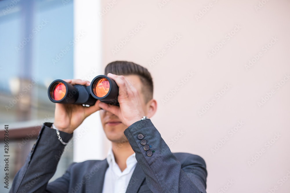 American businessman using binoculars in office. Spy of competitors. American businessman using binoculars in office. Spy of competitors.