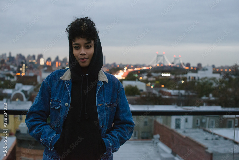 Portrait of young woman in hoodie on rooftop at sunset Portrait of young woman in hoodie on rooftop at sunset