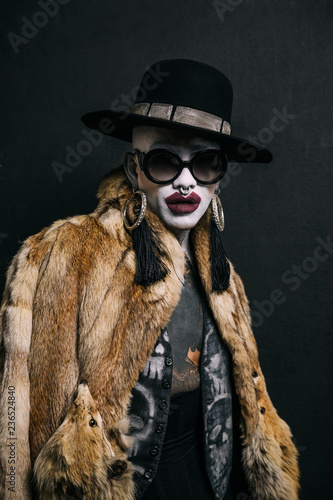 Bizarre fashion studio portrait with extreme makeup
