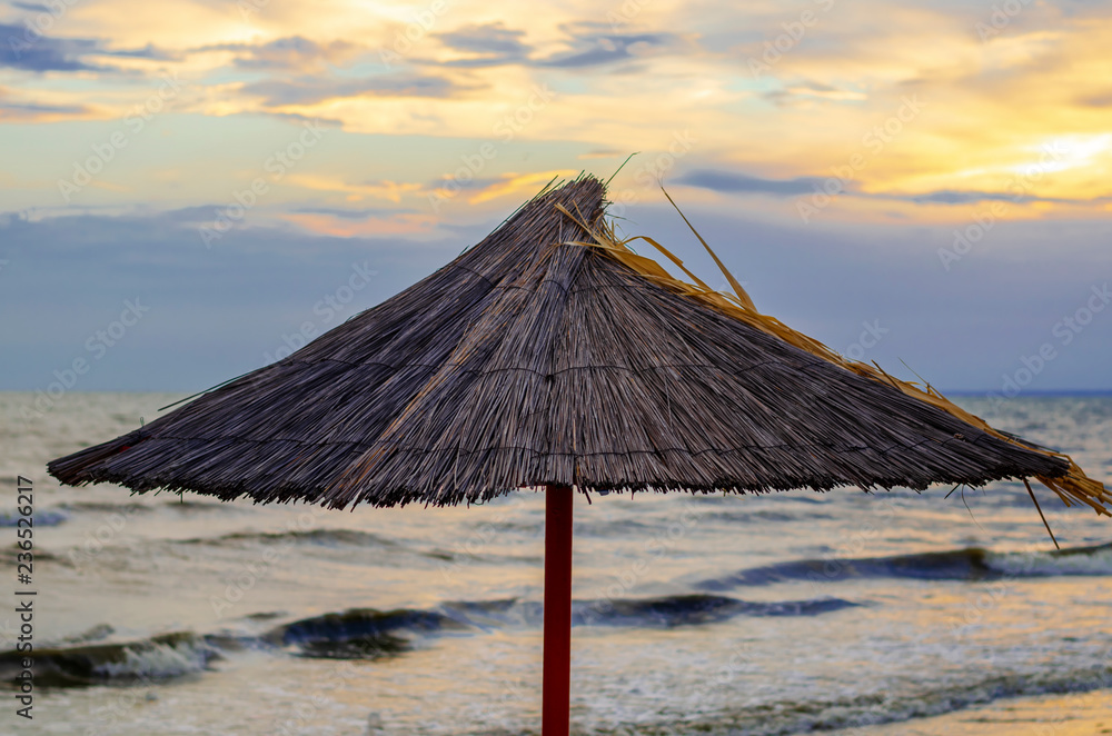 beach straw umbrellas on the sea coast. End of the beach season. empty beach