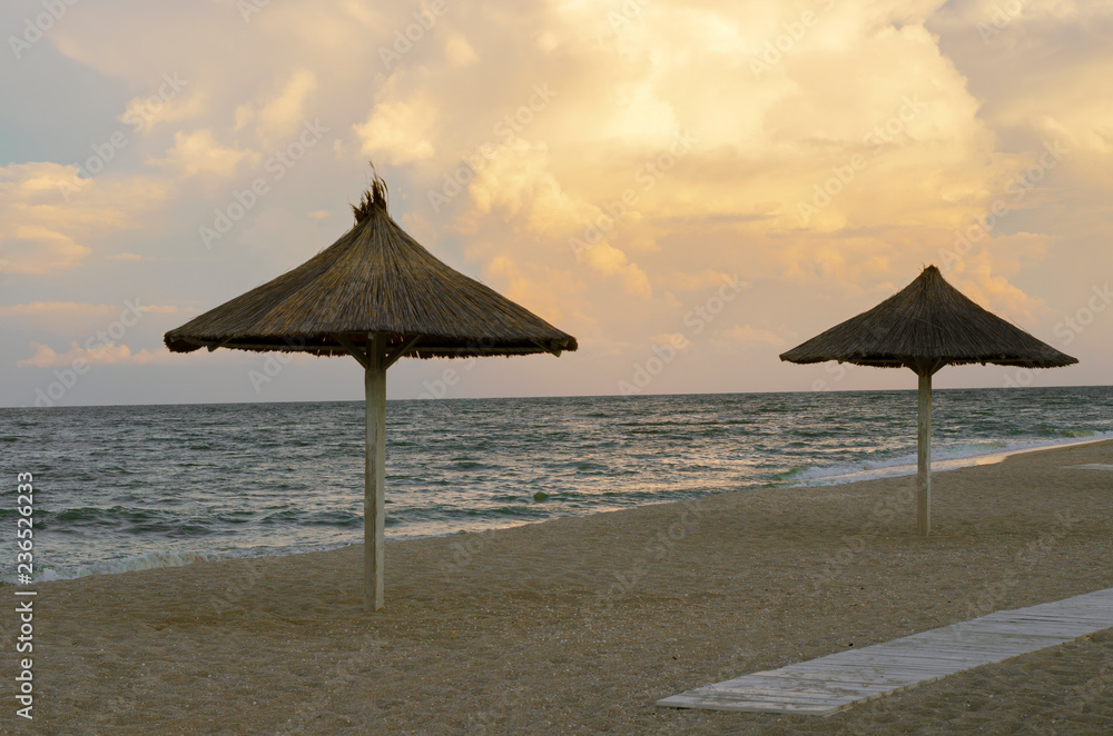 beach straw umbrellas on the sea coast. End of the beach season. empty beach