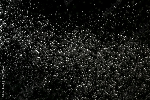 Black and white explosion of bubbles moving in water