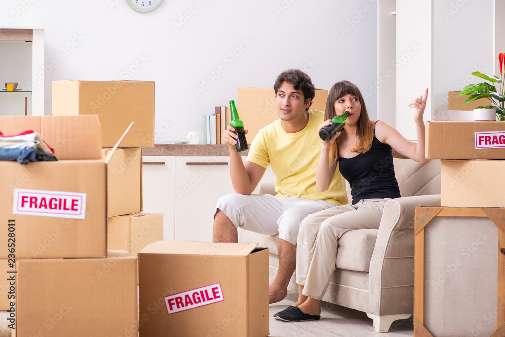 Young couple moving to new flat with fragile things Young couple moving to new flat with fragile things