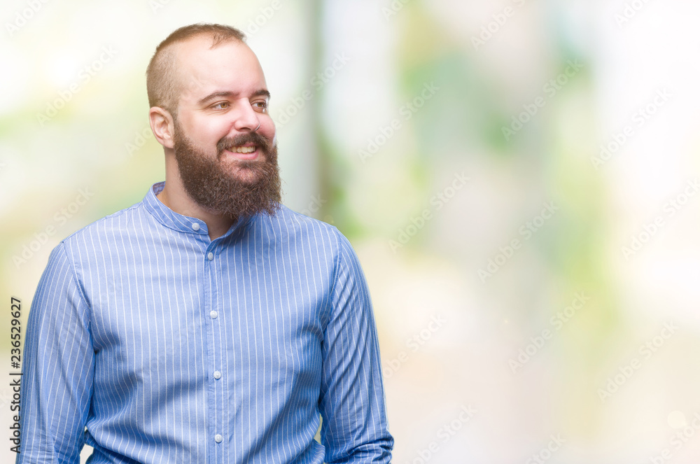 Young caucasian hipster man over isolated background looking away to side with smile on face, natural expression. Laughing confident. Young caucasian hipster man over isolated background looking away to side with smile on face, natural expression. Laughing confident.