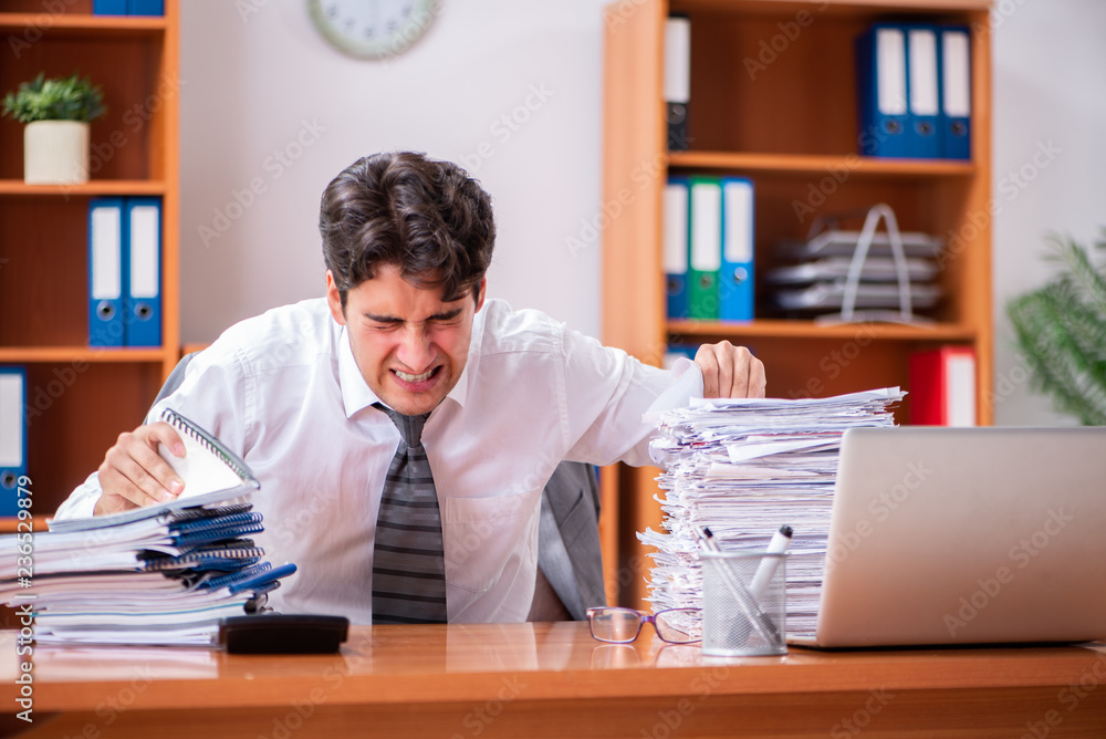 Young handsome businessman unhappy with excessive work Young handsome businessman unhappy with excessive work