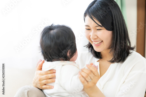 portrait of young asian mother and baby relaxing in living room