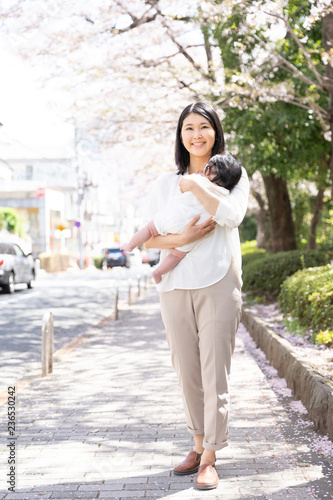 portrait of young asian mother and baby looking cherry blossom