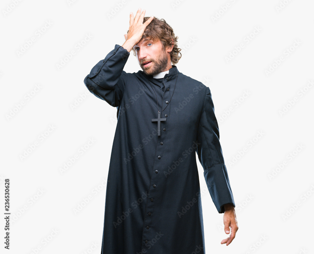 Handsome hispanic catholic priest man over isolated background surprised with hand on head for mistake, remember error. Forgot, bad memory concept.
