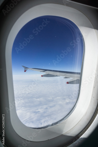 Looking through the window while flying above a sea of clouds
