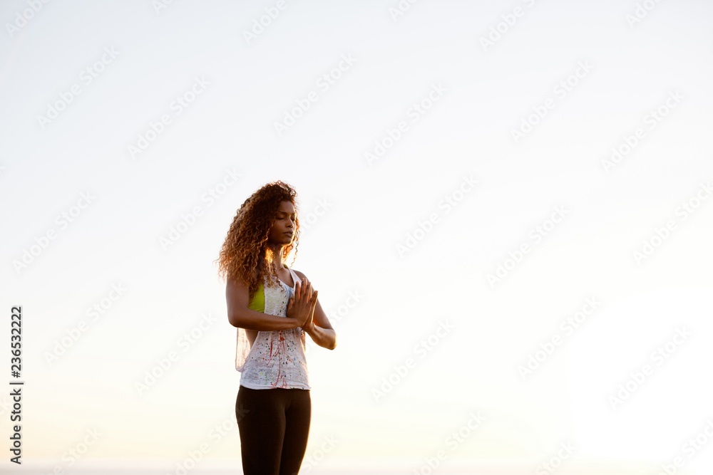 Fit, stylish woman practicing yoga at sunset on grass Fit, stylish woman practicing yoga at sunset on grass