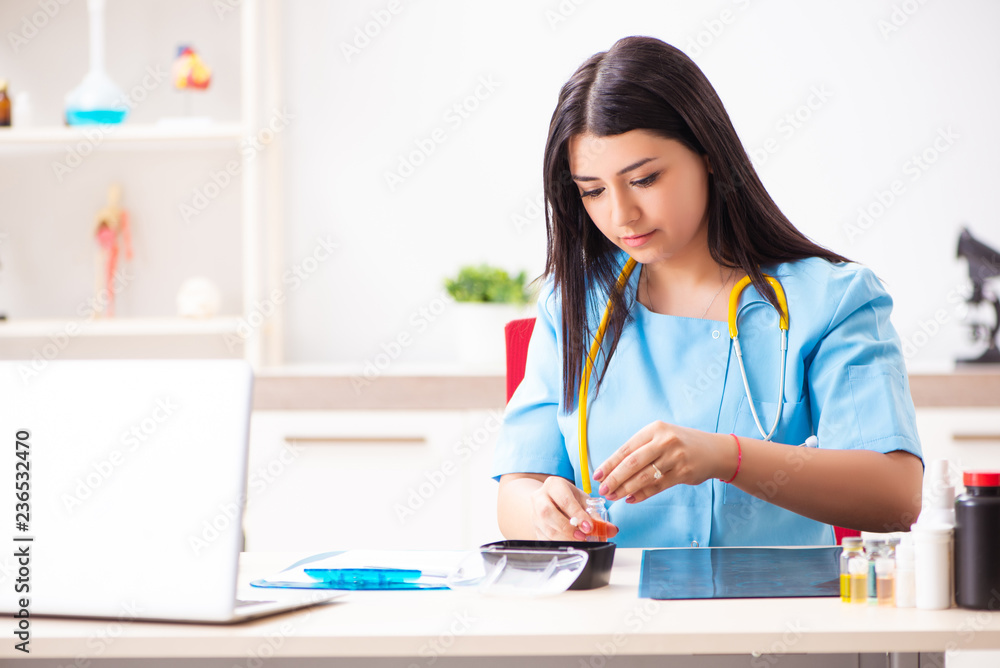 Young beautiful female doctor working in the clinic Young beautiful female doctor working in the clinic