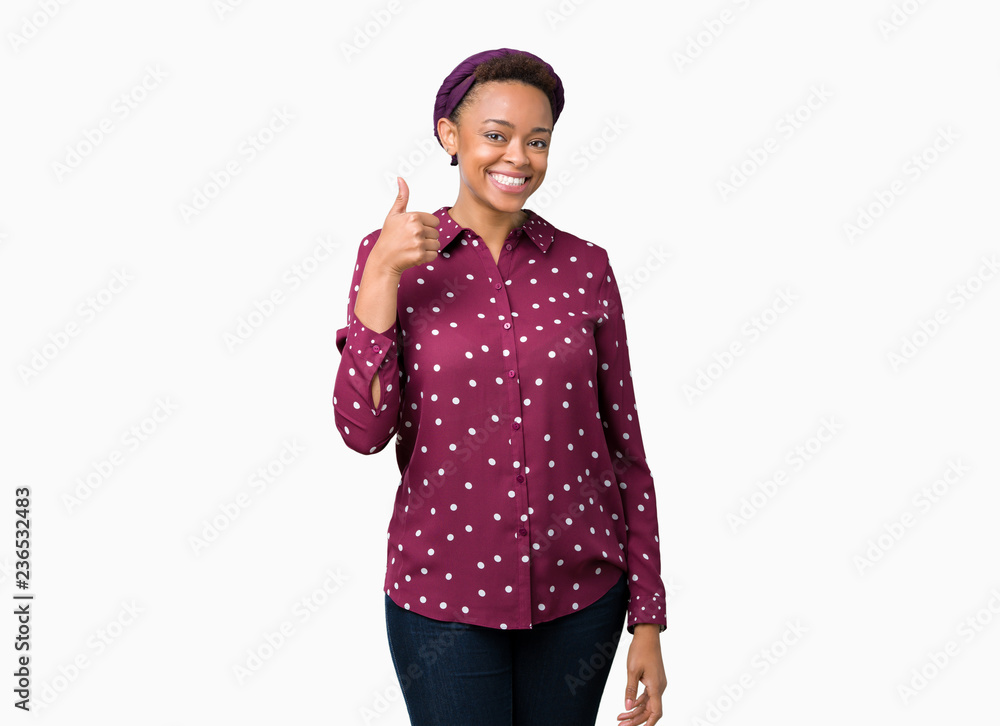 Beautiful young african american woman wearing head scarf over isolated background doing happy thumbs up gesture with hand. Approving expression looking at the camera showing success. Beautiful young african american woman wearing head scarf over isolated background doing happy thumbs up gesture with hand. Approving expression looking at the camera showing success.
