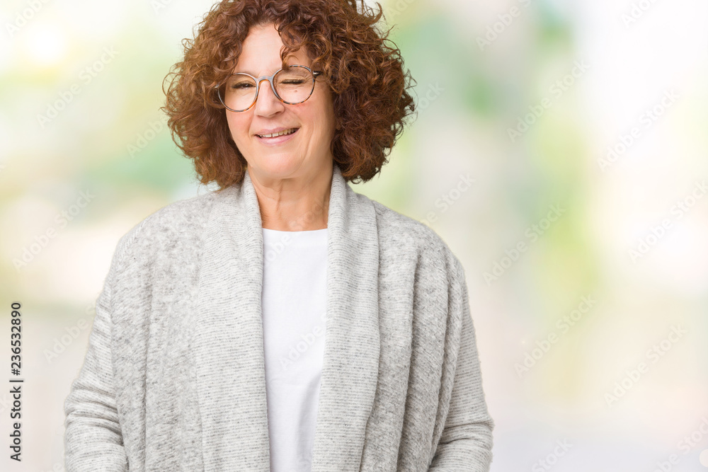 Beautiful middle ager senior woman wearing jacket and glasses over isolated background winking looking at the camera with sexy expression, cheerful and happy face. Beautiful middle ager senior woman wearing jacket and glasses over isolated background winking looking at the camera with sexy expression, cheerful and happy face.