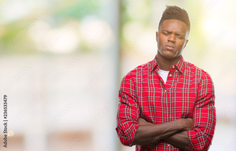 Obraz premium Young african american man over isolated background skeptic and nervous, disapproving expression on face with crossed arms. Negative person.