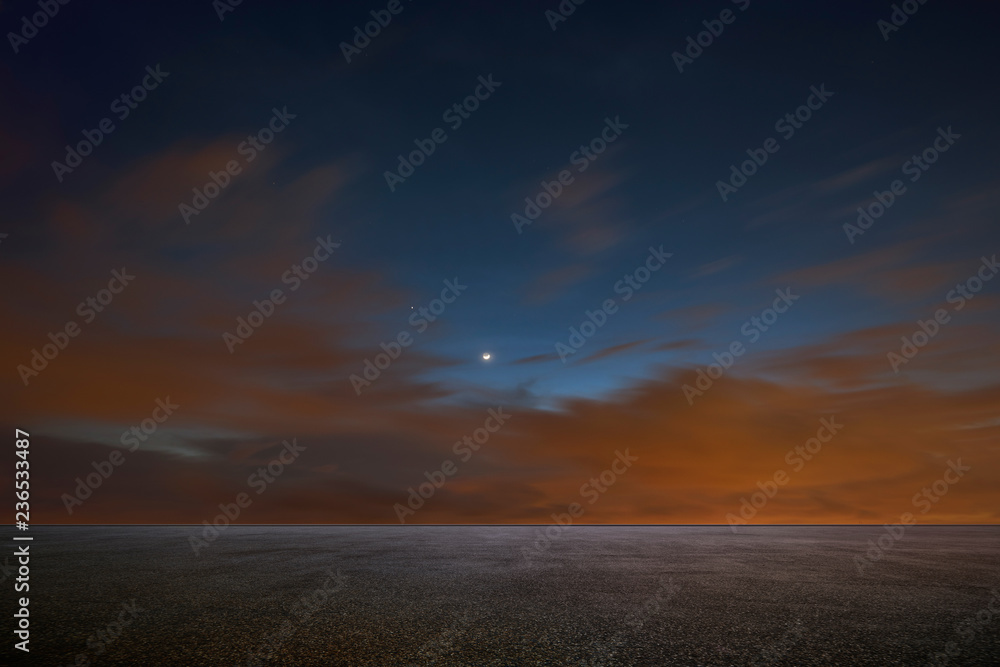 Empty asphalt floor with dramatic night sky .