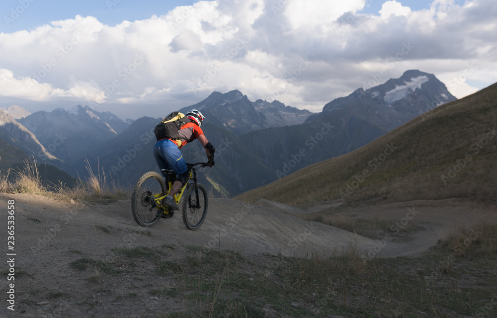 Man riding mountain bike downhill backcountry route Man riding mountain bike downhill backcountry route