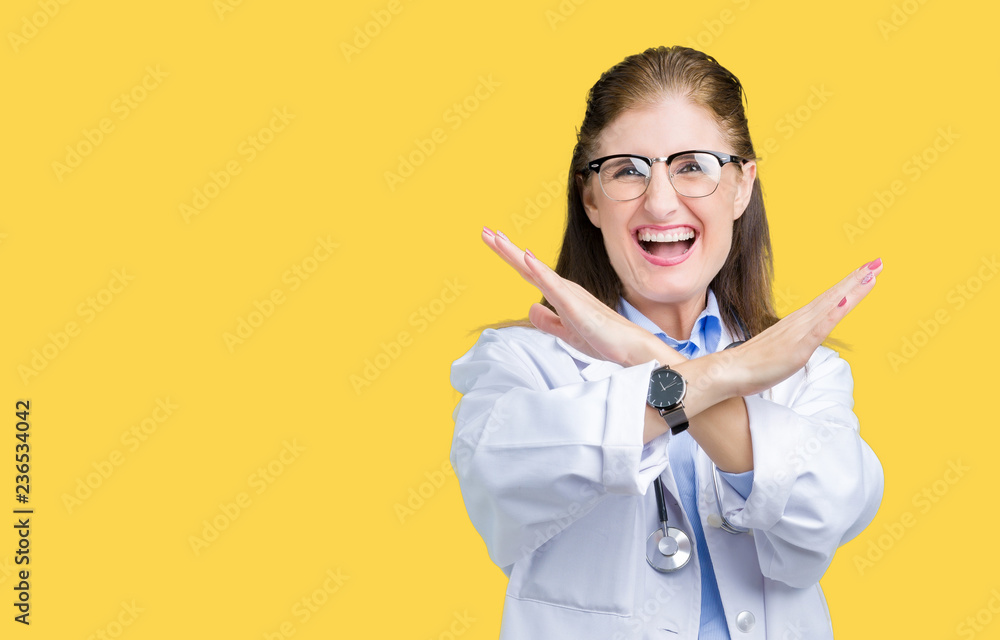 Middle age mature doctor woman wearing medical coat over isolated background Rejection expression crossing arms doing negative sign, angry face Middle age mature doctor woman wearing medical coat over isolated background Rejection expression crossing arms doing negative sign, angry face