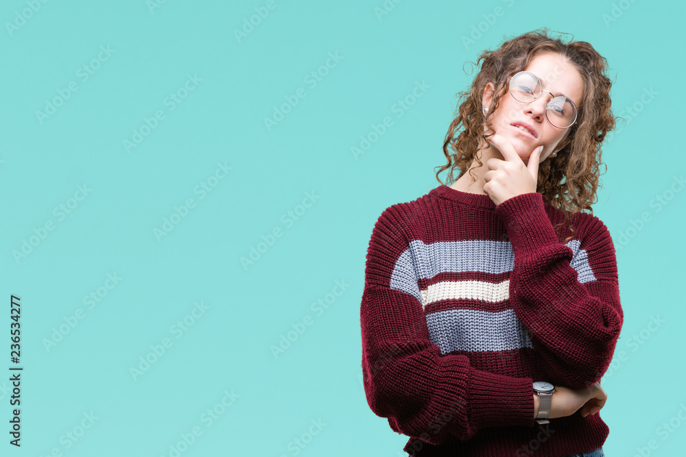Beautiful brunette curly hair young girl wearing glasses over isolated background looking confident at the camera with smile with crossed arms and hand raised on chin. Thinking positive. Beautiful brunette curly hair young girl wearing glasses over isolated background looking confident at the camera with smile with crossed arms and hand raised on chin. Thinking positive.