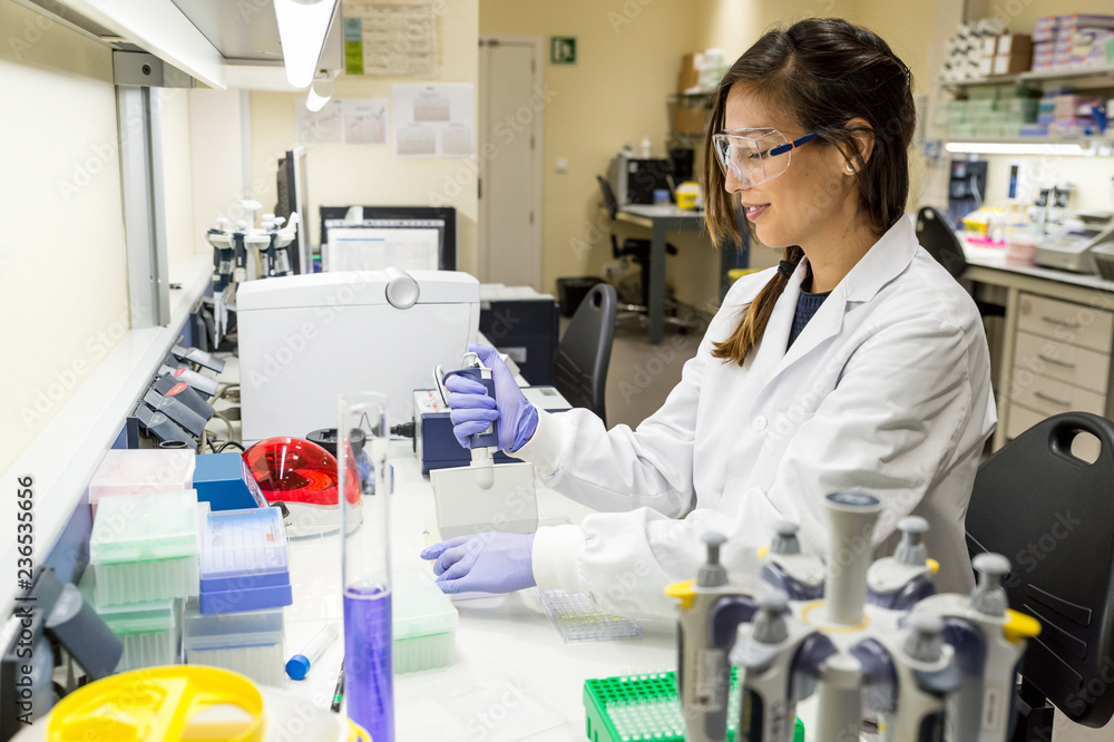Female scientist using a pipette in a DNA laboratory Female scientist using a pipette in a DNA laboratory