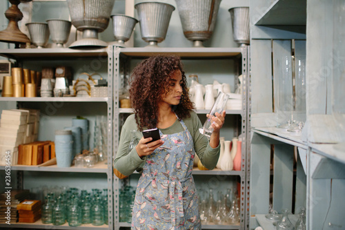 Young woman arranging goods in warehouse photo