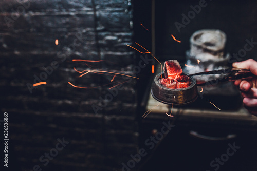 Shisha hookah with red hot coals. Sparks from breathe. Modern hookah with coconut charcoal for relax and shisha smoke. Hookah and sparks from coals. Another view. Shisha, spark,spark, hookah sparks.