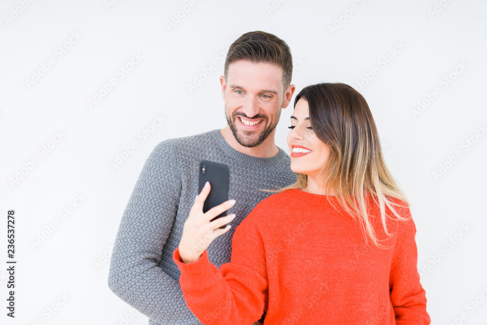 Beautiful young couple in love, kissing and hugging each other using smarthpone Beautiful young couple in love, kissing and hugging each other using smarthpone