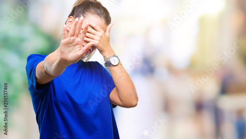 Young beautiful woman wearing casual blue t-shirt over isolated background covering eyes with hands and doing stop gesture with sad and fear expression. Embarrassed and negative concept.