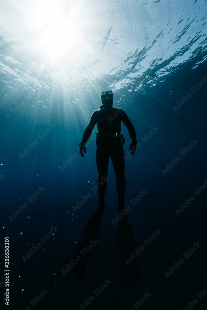 Freediver hanging in tranquil water Freediver hanging in tranquil water