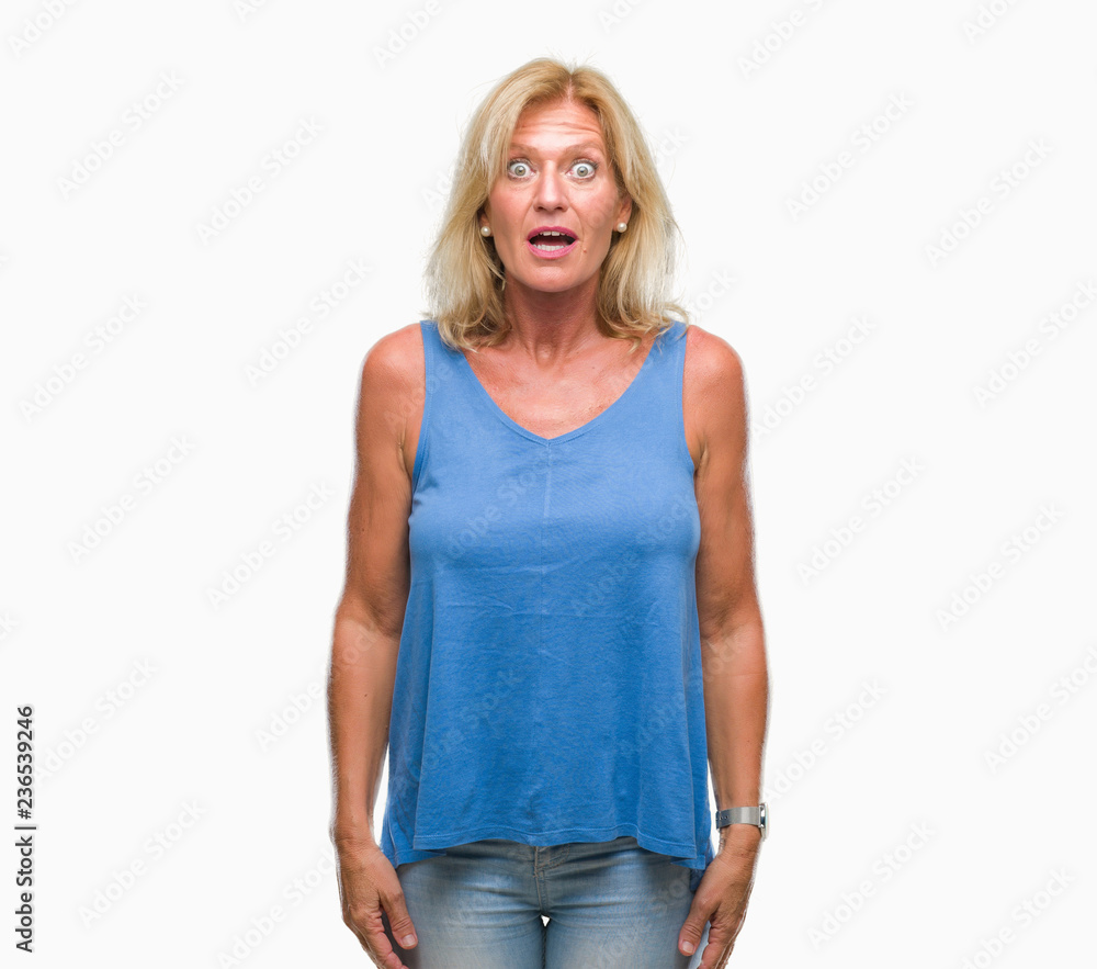 Fototapeta premium Middle age blonde woman over isolated background afraid and shocked with surprise expression, fear and excited face.
