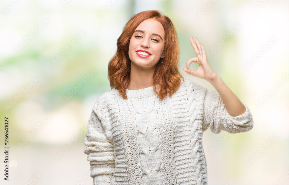 Young beautiful woman over isolated background wearing winter sweater smiling positive doing ok sign with hand and fingers. Successful expression. Young beautiful woman over isolated background wearing winter sweater smiling positive doing ok sign with hand and fingers. Successful expression.