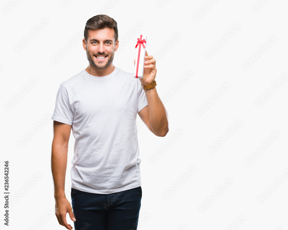 Young handsome man in love giving valentine present over isolated background with a happy face standing and smiling with a confident smile showing teeth Young handsome man in love giving valentine present over isolated background with a happy face standing and smiling with a confident smile showing teeth