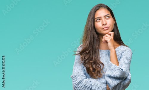 Fotografie, Obraz Young beautiful arab woman wearing winter sweater over isolated background with hand on chin thinking about question, pensive expression