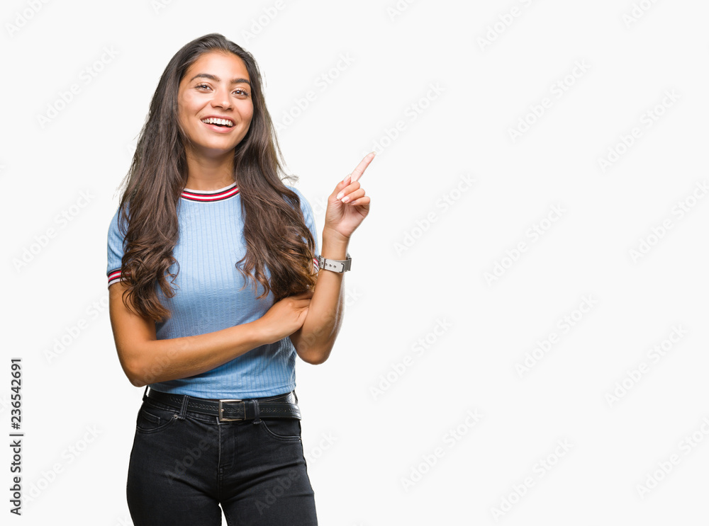 Young beautiful arab woman over isolated background with a big smile on face, pointing with hand and finger to the side looking at the camera. Young beautiful arab woman over isolated background with a big smile on face, pointing with hand and finger to the side looking at the camera.