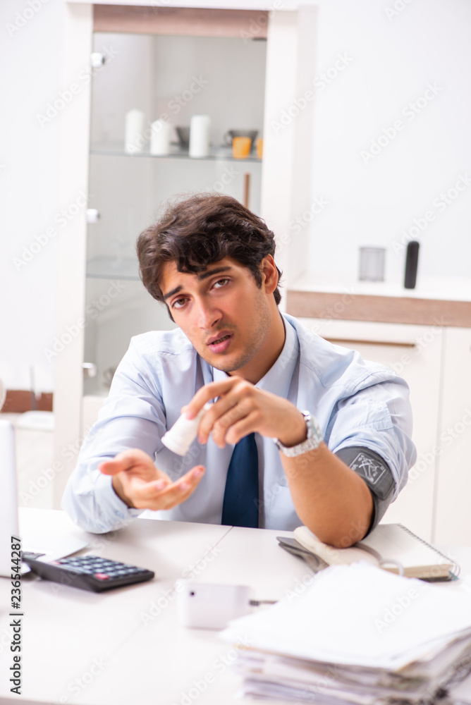 Man under stress measuring his blood pressure