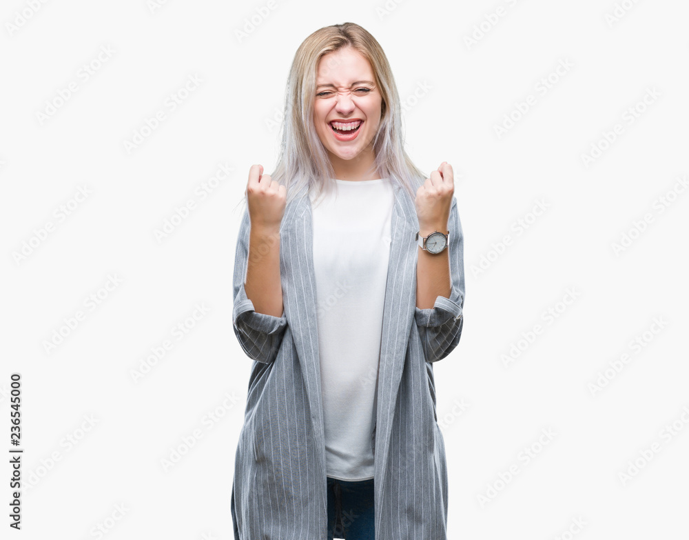 Young blonde business woman wearing jacket over isolated background celebrating surprised and amazed for success with arms raised and open eyes. Winner concept. Young blonde business woman wearing jacket over isolated background celebrating surprised and amazed for success with arms raised and open eyes. Winner concept.