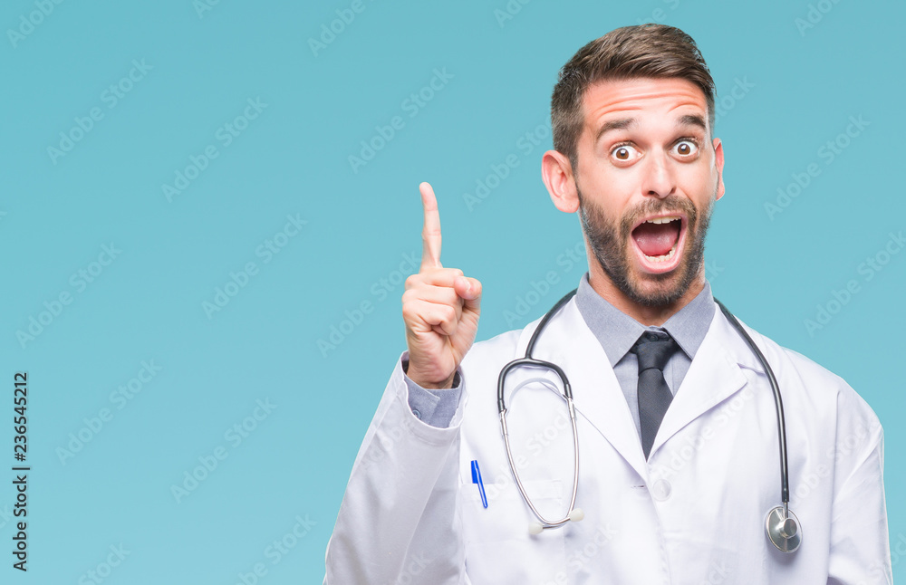 Young handsome doctor man over isolated background pointing finger up with successful idea. Exited and happy. Number one. Young handsome doctor man over isolated background pointing finger up with successful idea. Exited and happy. Number one.